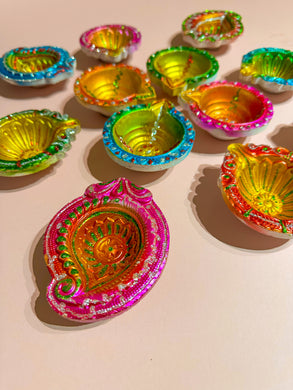 painted miti diya divas bright coloured. Decorated divas with glitter.